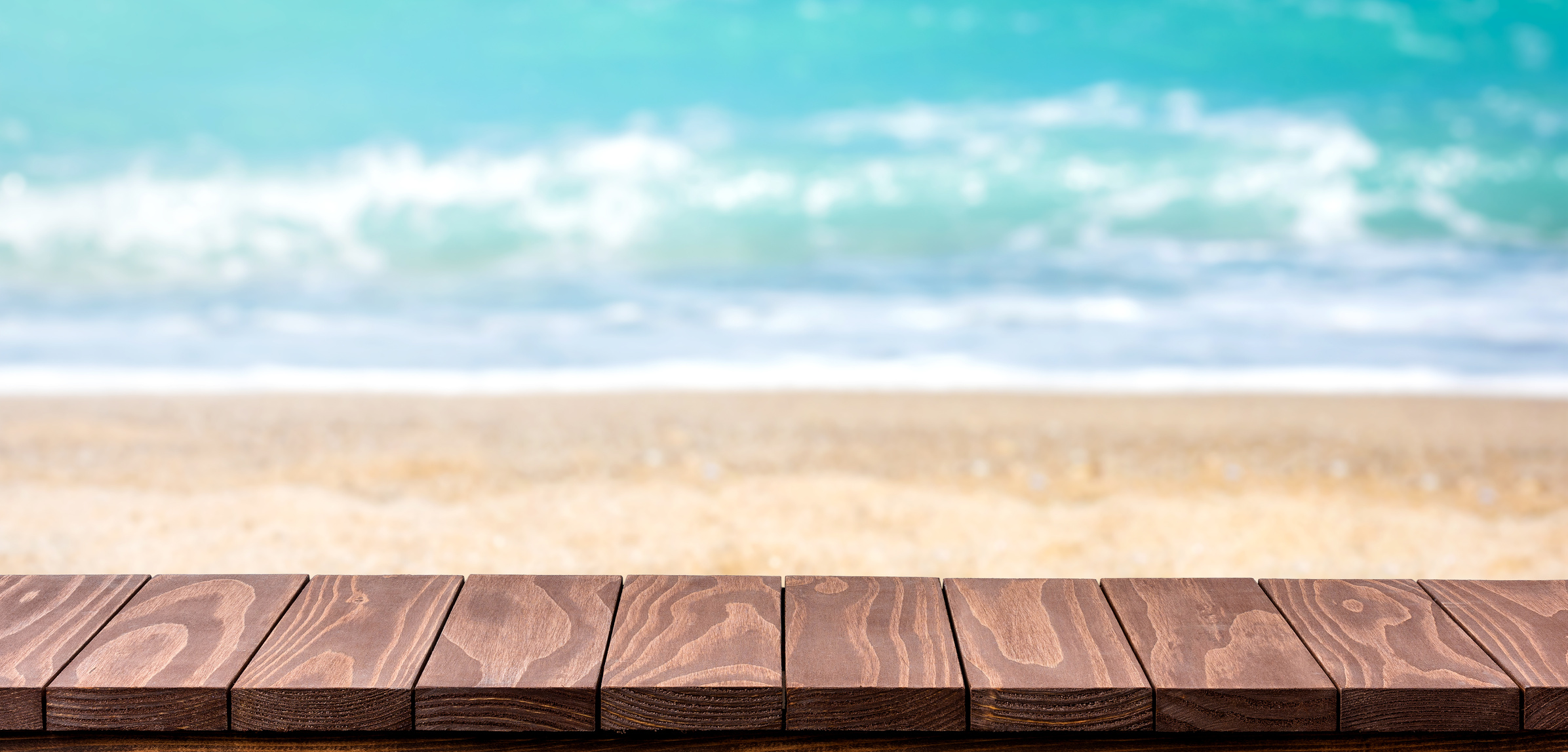 Empty wooden table with blurred beach background